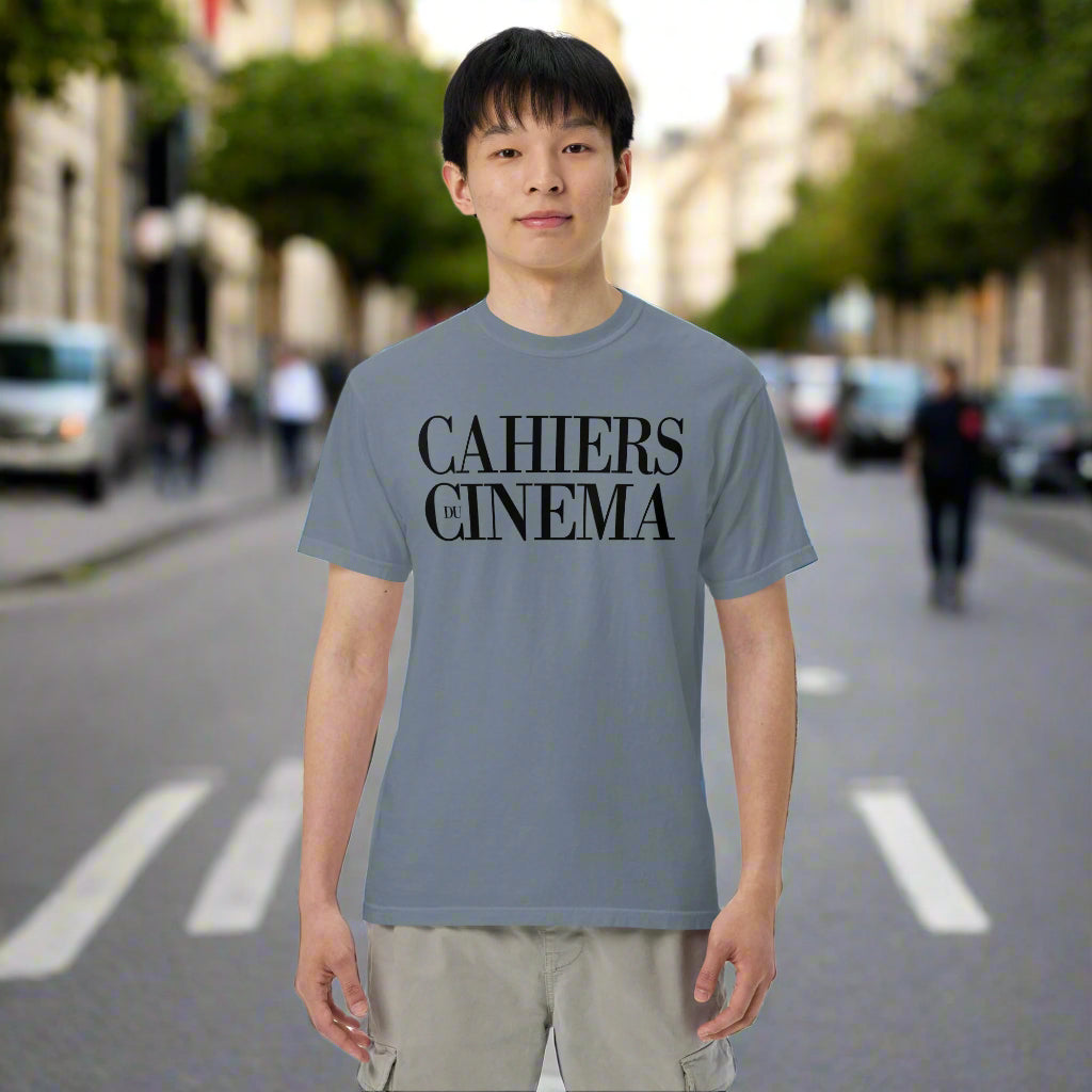 Person wearing a gray t-shirt with 'CAHIERS CINEMA' text on a city street.